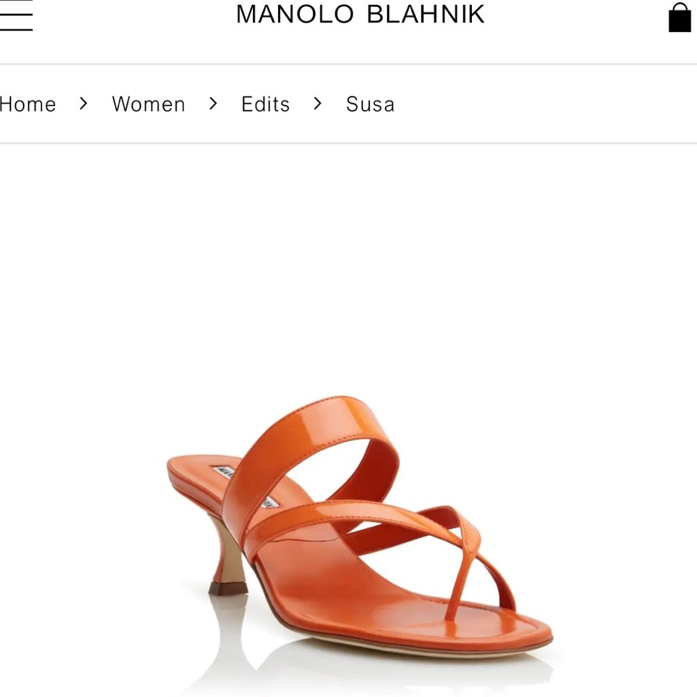 Bright orange leather open toe mules featuring crossover and kitten heel.